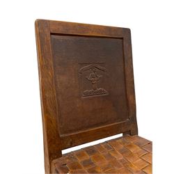 Mouseman - circa. 1930s set of six (4+2) oak dining chairs, panelled back carved with the Bagshawe family crest, the moto 'Forma Flos Fama Flatus' over an arm grasping a bugle-horn with ribbon tie and Yorkshire rose motif, adzed frame, leather lattice strap seat, on octagonal supports united by stretchers, two carvers and four side chairs, each carved with mouse signature, by Robert Thompson of Kilburn 

Provenance: Owned since manufacture by the Bagshawe family, descendants of the Staithes Group Artist Joseph Richard Bagshawe RBA (1870-1909).