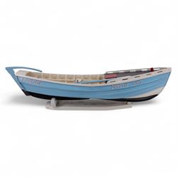 Wooden model of the Whitby fishing coble WY.17 G.Burdon 'Dorothy', painted in blue and white with red detail, with rudder and oars, on a painted wooden stand, L73cm, H20cm