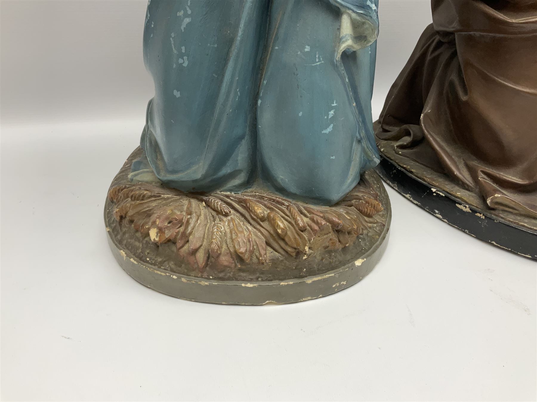 Two religious painted plaster figures of Mary and Joseph kneeling on oval plinths, with impressed mark 'Raffl et Cie Paris', H60cm 