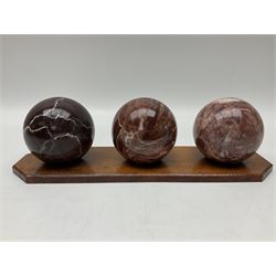 Set of three marble spheres on a elongated octagonal wooden base, H12cm