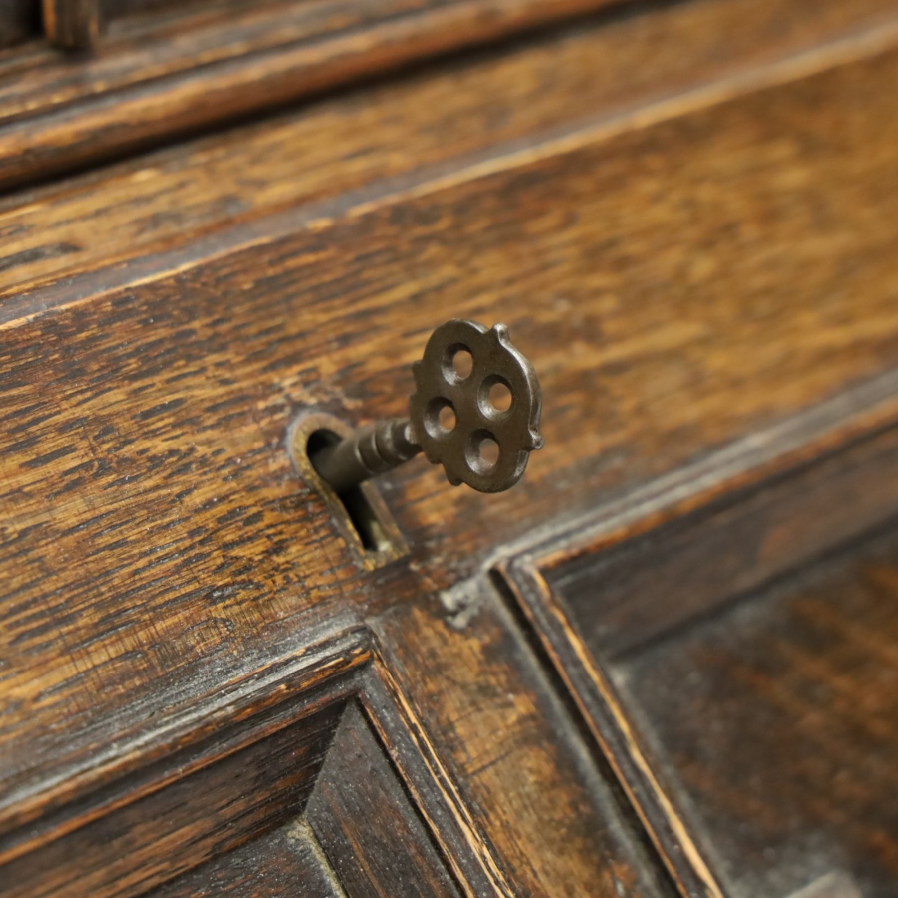 Early 20th century Jacobean Revival oak bureau-bookcase, astragal glazed doors enclosing two adjustable shelves, over geometric panelled fall-front enclosing fitted interior, over two drawers, raised on a spiral-turned base with barley-twist stretchers and compressed bun feet