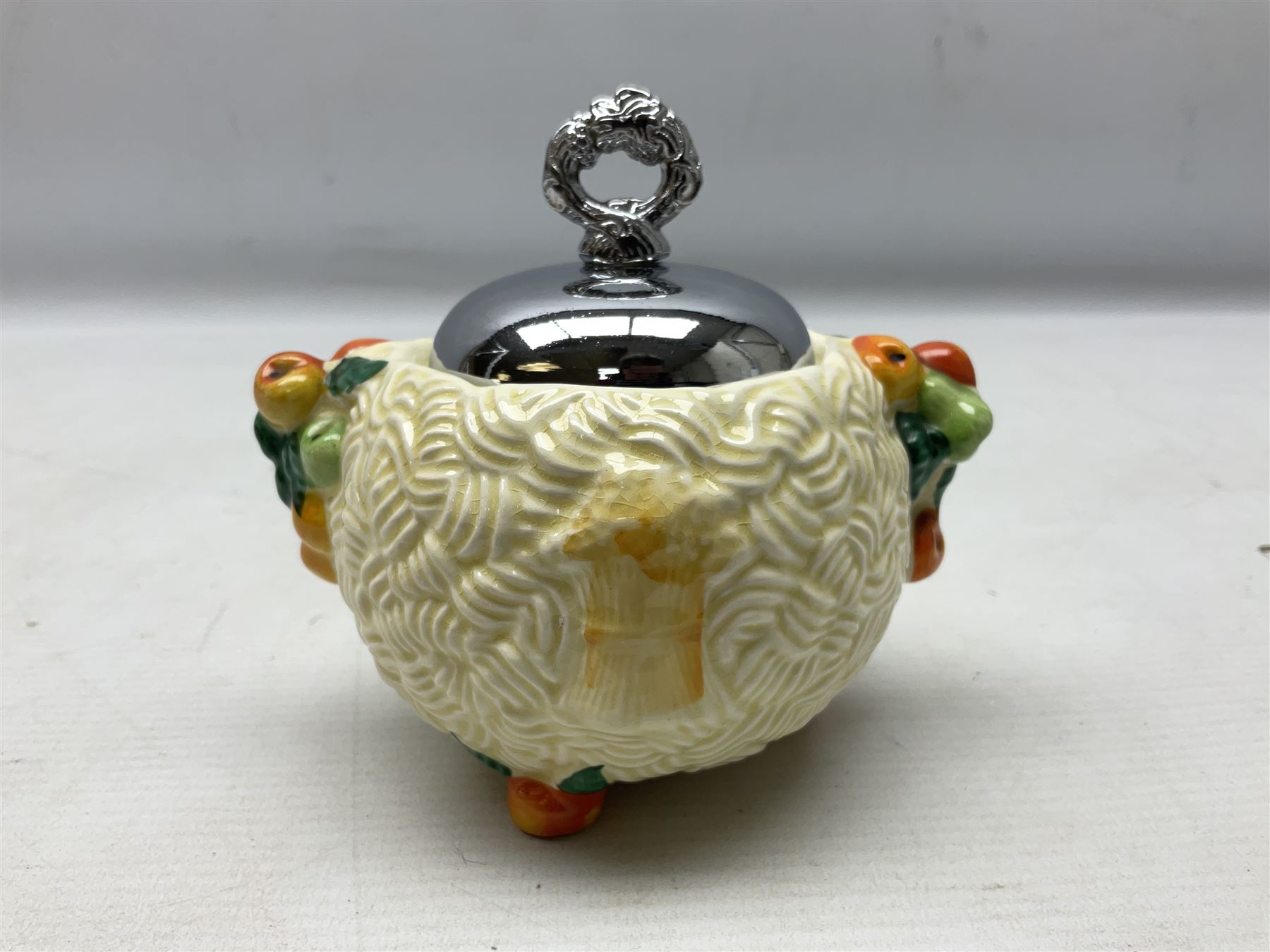 Clarice Cliff Celtic Harvest pattern sugar bowl, with original silver plate cover upon basket weave effect spherical body decorated with raised stylised fruit, H11cm