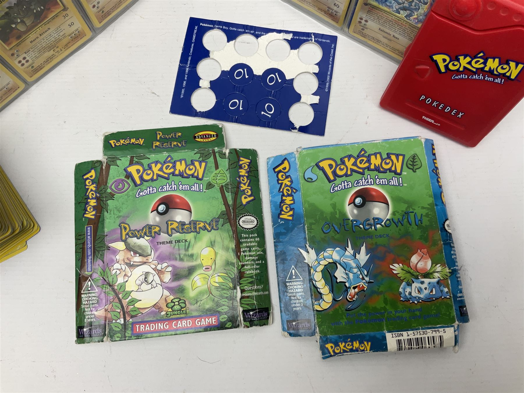 Collection of Pokemon trading cards, mostly 1999 Wizards Pokemon cards to include holo Charizard 4/102, first edition holo Machamp 8/102, further holographic cards; Dark Flareon 35/82 and Dark Vaporeon 45/82, cards from themed sets and 4th edition prints; 1998 Electronic Pokédex with cardboard boxes for themed decks Blackout, Overgrowth and Power Reserve Jungle, along with a large quantity of energy and trainer cards 