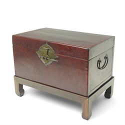 Chinese red lacquered chest on hardwood stand, with twin carrying handles, including stand...