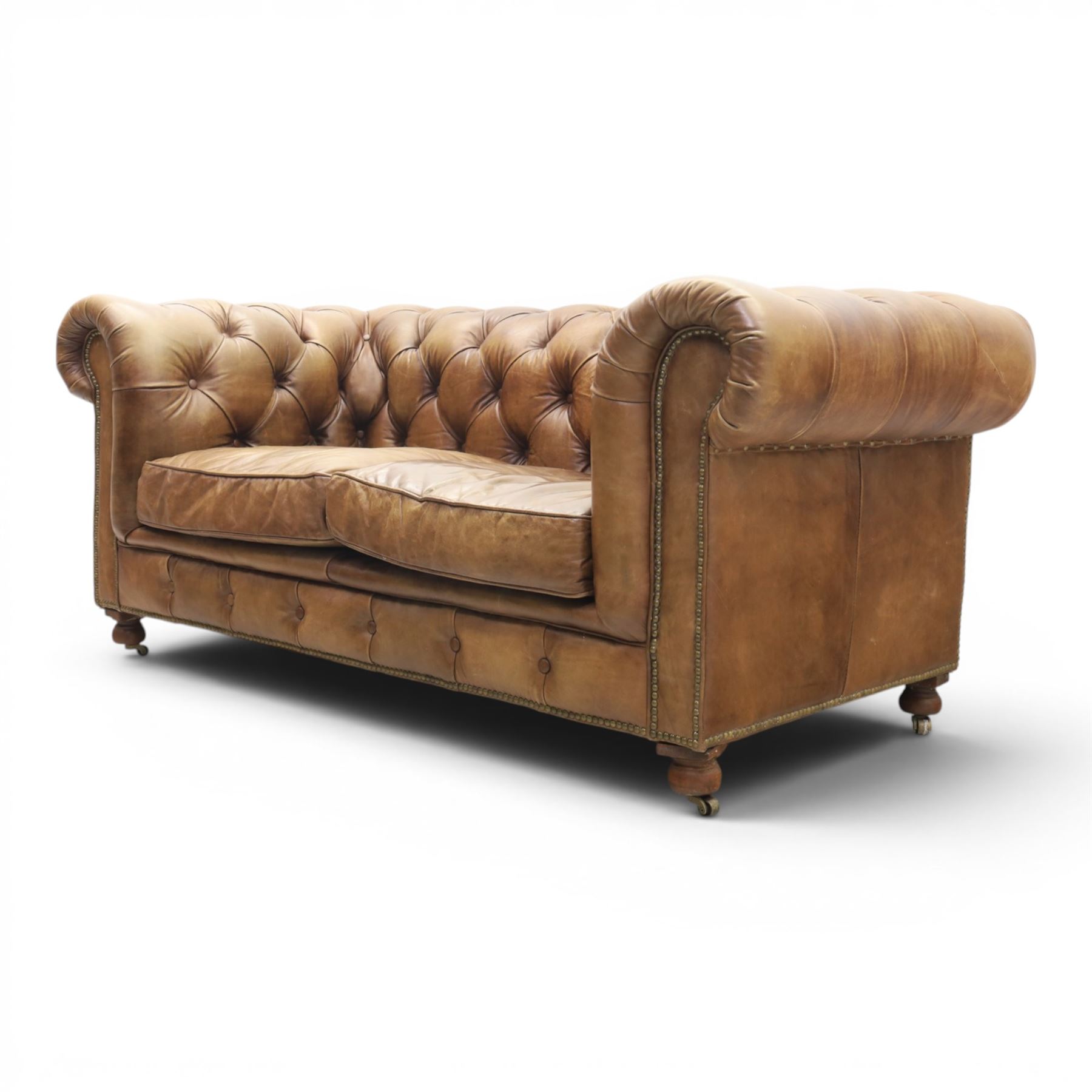 HALO - Chesterfield style two seat sofa upholstered in buttoned brown leather with stud work, on turned feet with castors