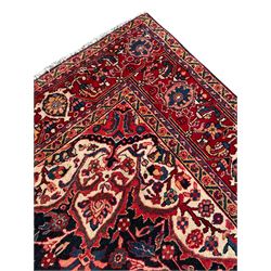 Persian Hamadan indigo and red ground carpet, large central medallion decorated with projecting palmette motifs, the surrounding field decorated with trailing branches and flower heads, crimson ground border decorated with stylised plant motifs, within floral pattern guard stripes 