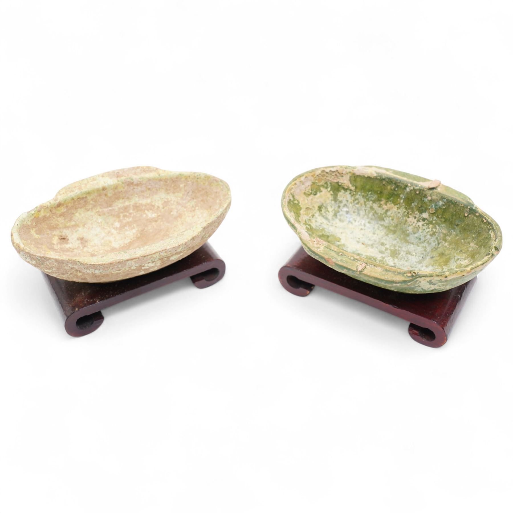 Two small Chinese terracotta 'ear' shaped wine cups, probably Western Han Dynasty c.206BC-24AD, one with green glaze, each on hardwood stand, W12cm (2)