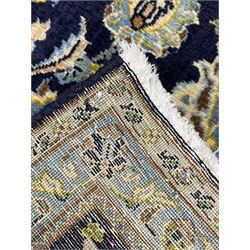 Persian Kashan indigo ground rug, central floral pattern pole medallion, the field decorated with palmettes united by trailing branches, repeating floral pattern border within guard stripes