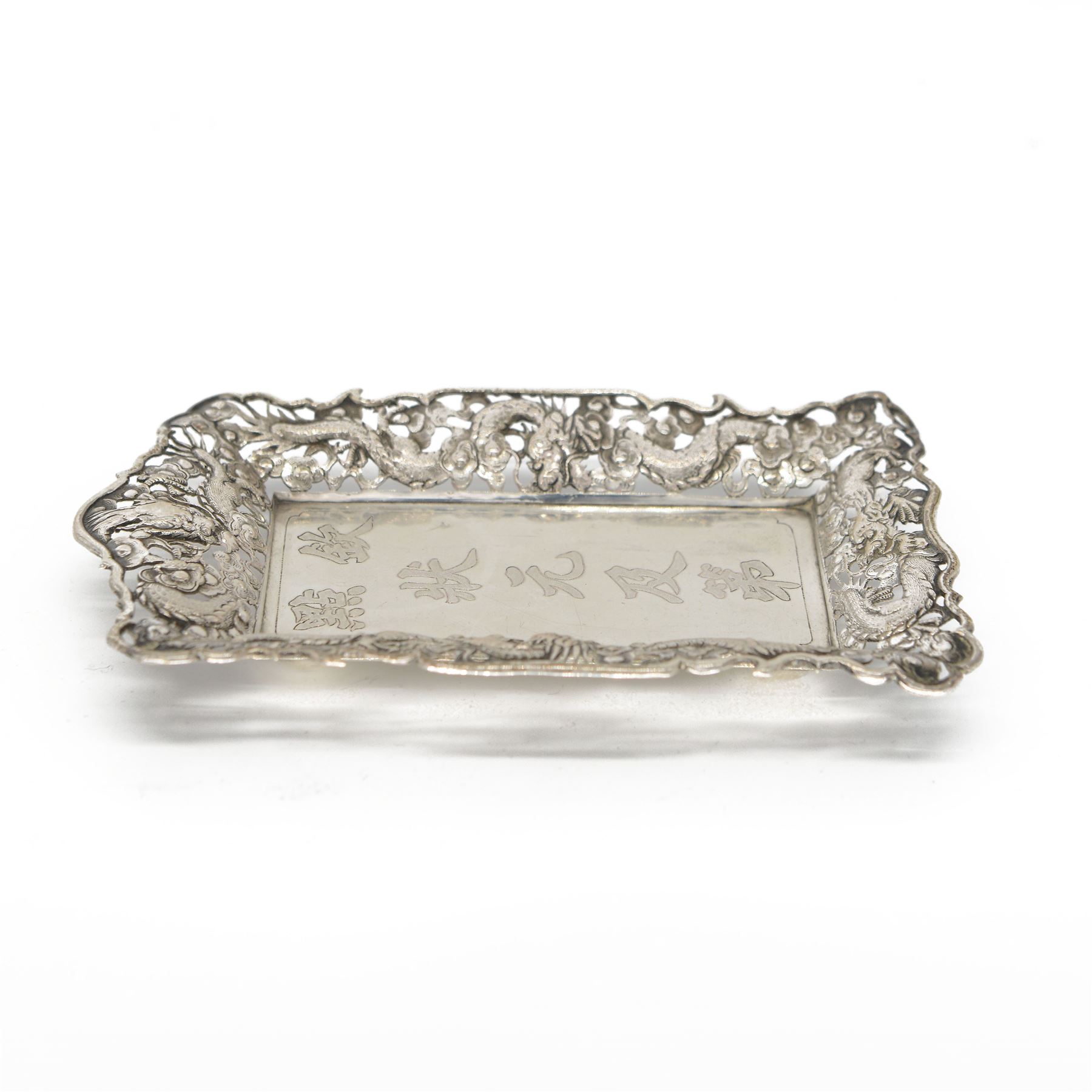Chinese export pin tray, of rectangular form, the pierced sides embossed with dragons amongst flowers, stamped with character marks and maker's mark for Hungchong & Co, L13cm 