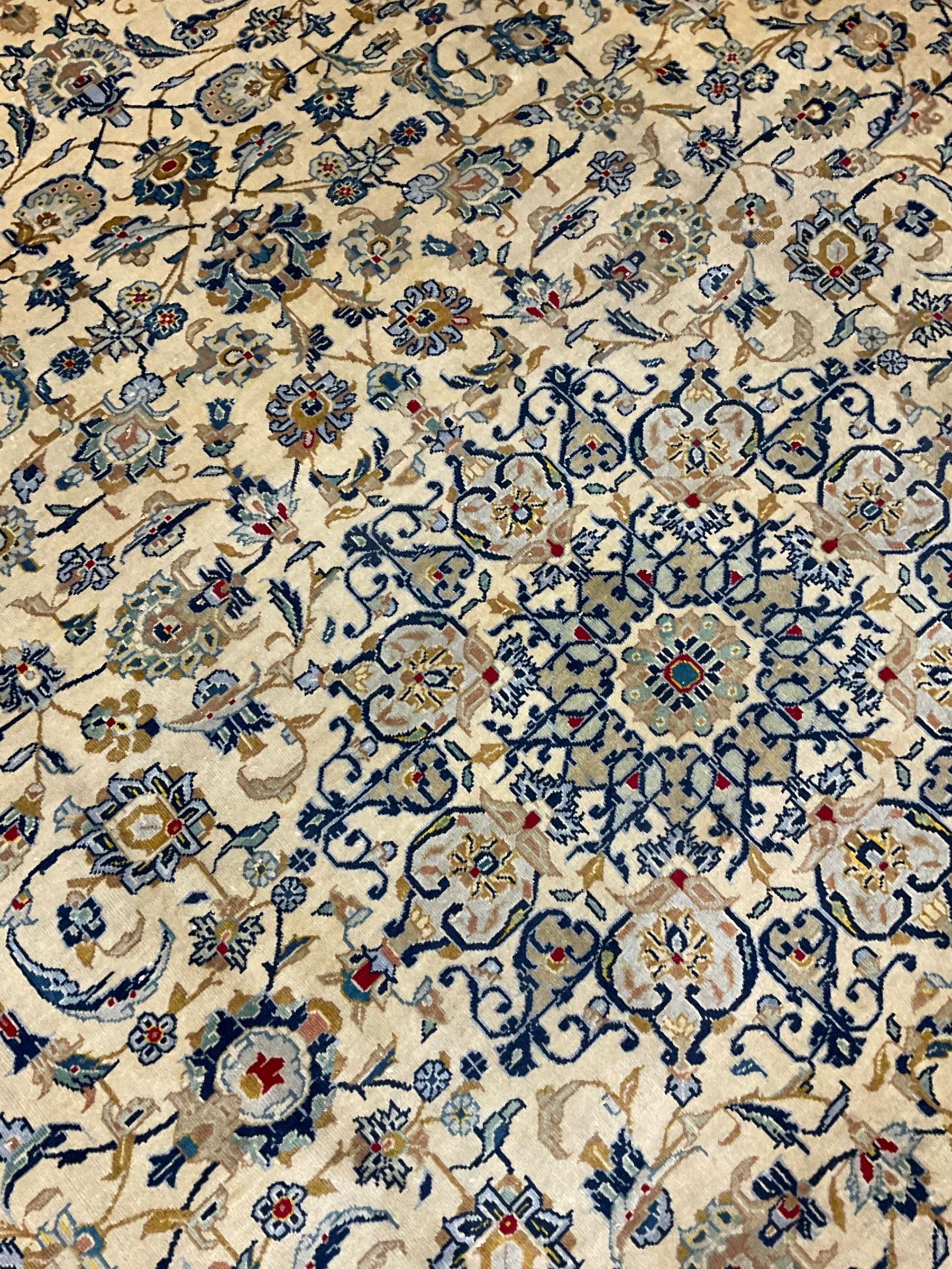 Central Persian Kashan carpet, decorated all-over with interlacing floral design, scrolling border with stylised plant motifs, with signed panel
