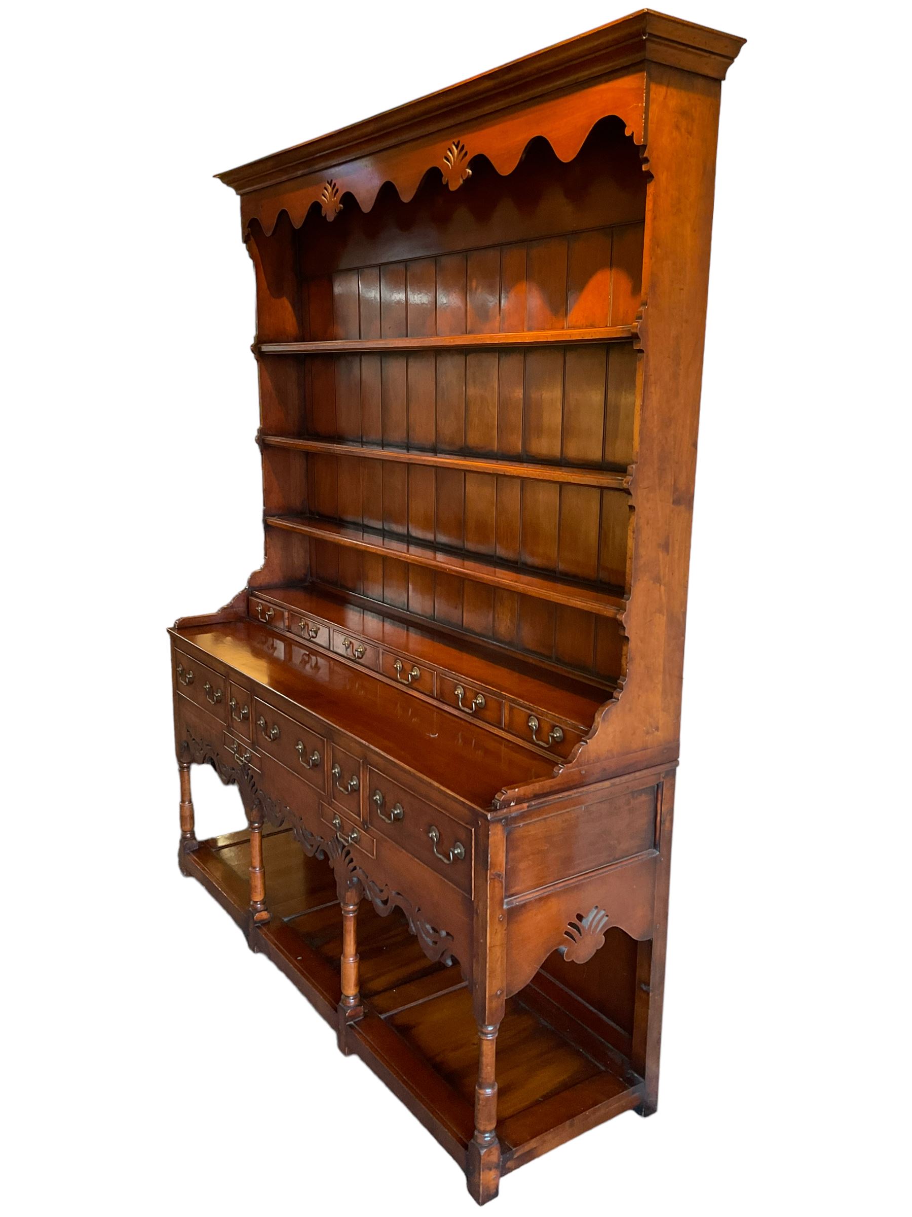 George III design cherry wood dresser, the projecting cornice over shaped frieze with pierced shell decoration, fitted with three shelves over six spice drawers, the base fitted with three long and two short drawers with cock-beaded facias, shaped and pierced apron over turned supports and panelled pot board base 