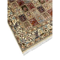 Persian Heriz design rug, ivory ground with rectangular panels each depicting garden scenes of tree of life, plants and Boteh motifs, the guarded border decorated with wildlife and bird scenes