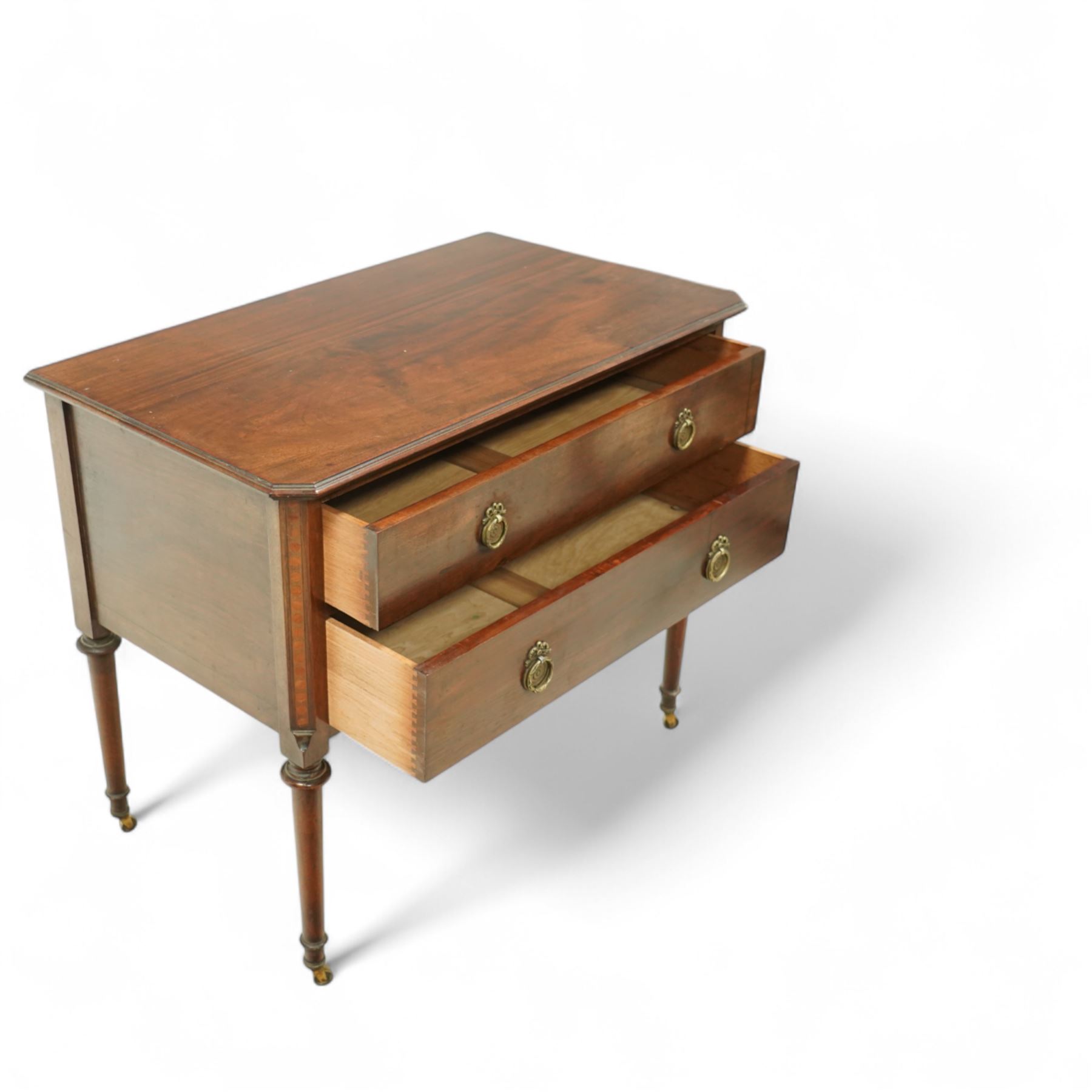 Early 20th century Regency-inspired mahogany two-drawer chest, rectangular top with moulded edge and shaped corners, above two full-width graduated drawers with ring handles, supported on turned tapered legs with brass castors                                                                                                                                                      
