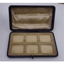 Set of six early 20th century silver mounted tortoiseshell place card holders by Asprey, the rectangular silver reed and ribbon frame bordering a central tortoiseshell panel inlaid with a silver floral motif, upon an oblong foot, hallmarked Asprey & Co Ltd, London 1913, H3cm, contained within a tooled leather fitted case with velvet and silk lined interior 
