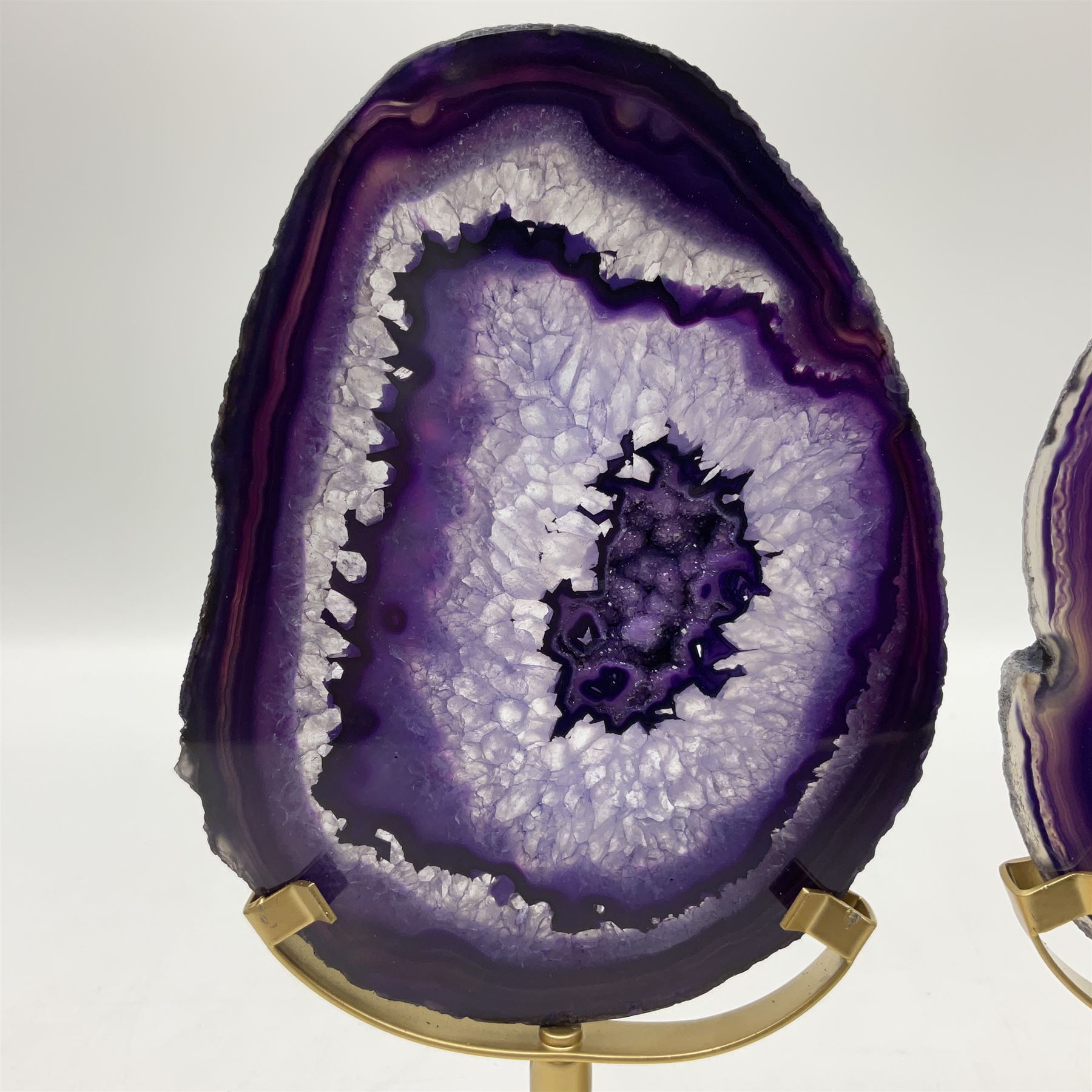 Pair of purple agate slices, polished with rough edges raised upon gilt metal stands