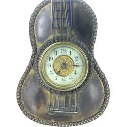 British - United Clock Company, early 20th century strut clock with a timepiece spring wound movement, enamel dial with Arabic numerals, spade hands and  gilt dial centre, decorative brass metal case in the form of a six string guitar with a folding stand, movement wound and set from the rear.