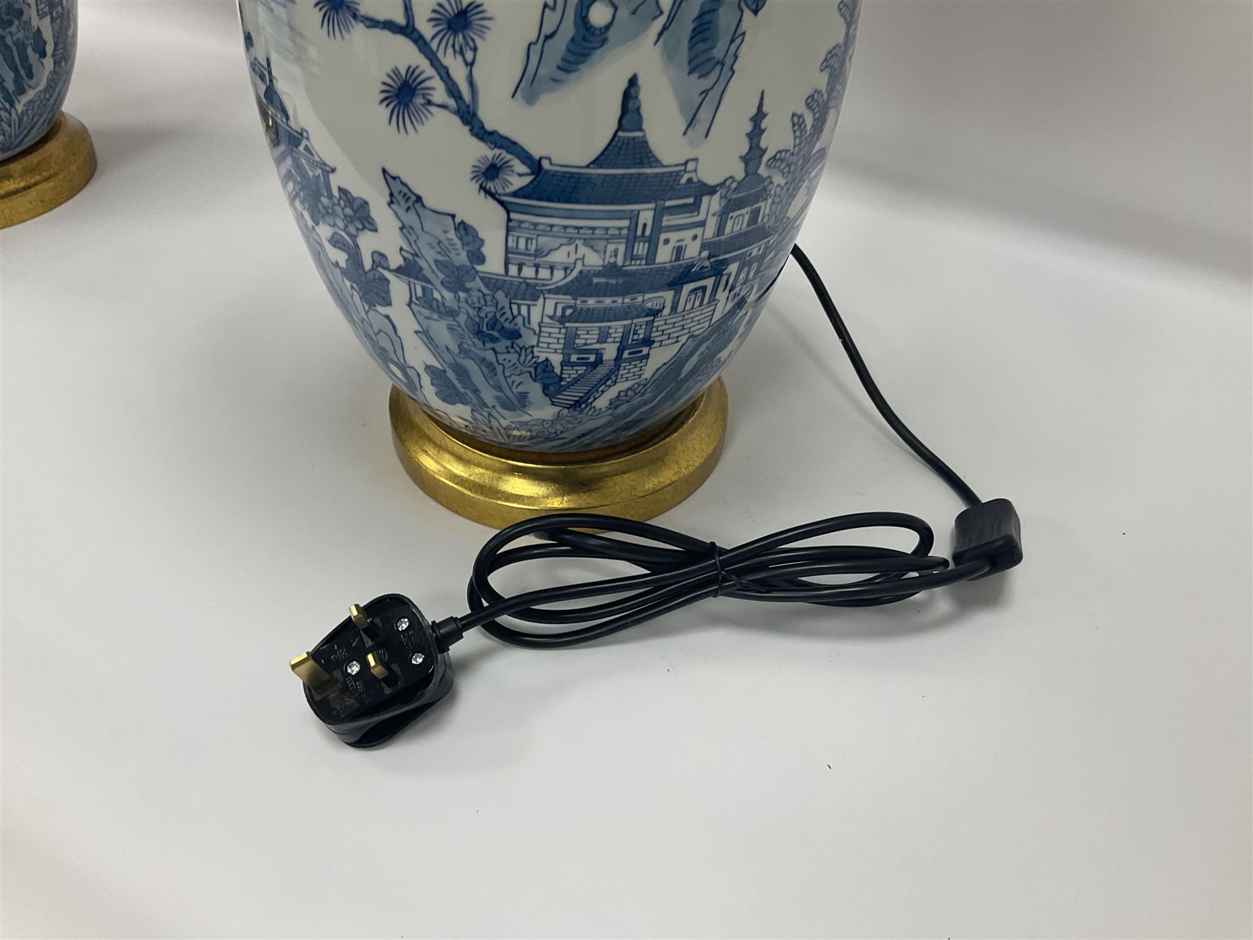 Pair of Chinese table lamps of baluster form, each decorated with landscape scene, raised upon gilt circular base, including shade H63cm