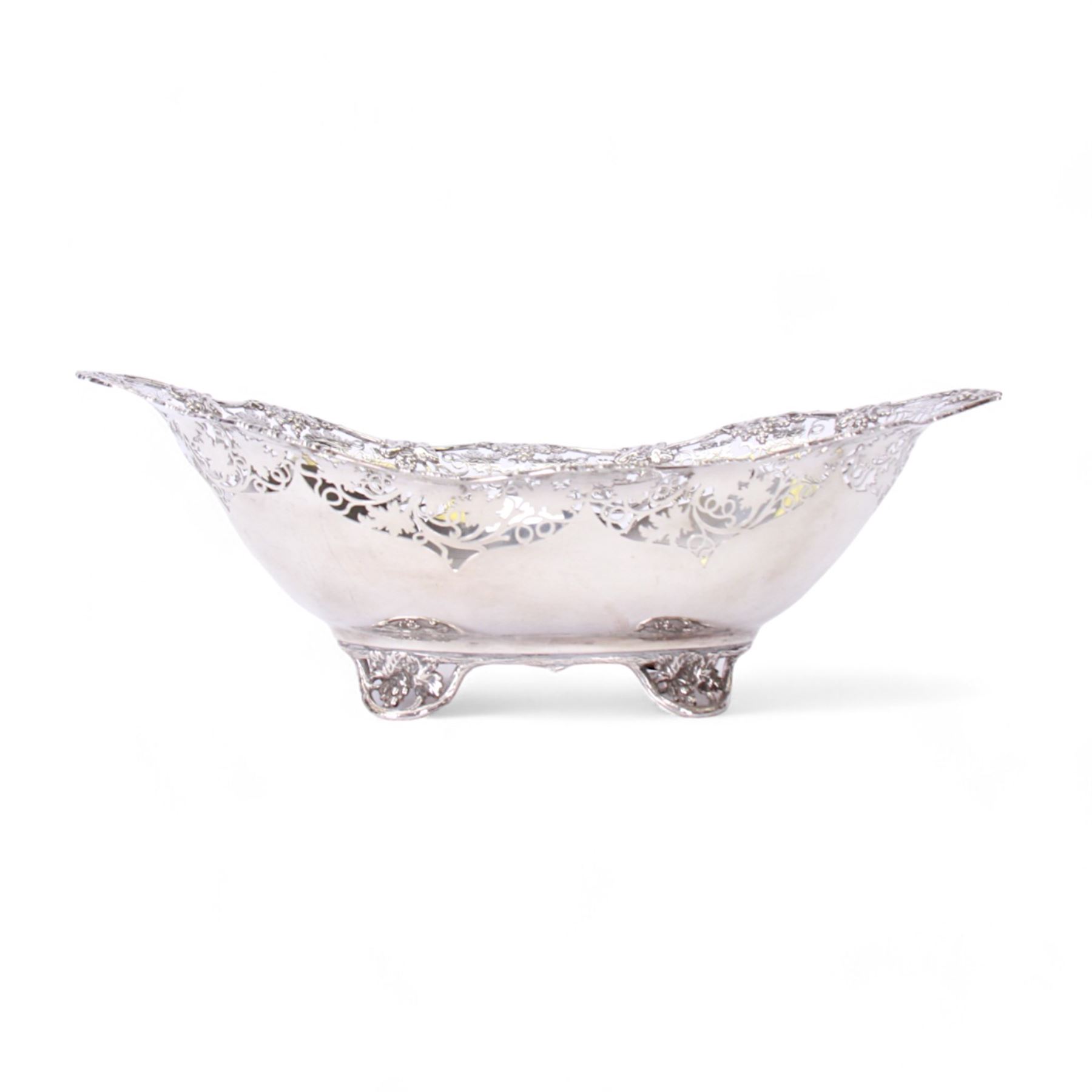 Early 20th century silver bowl, of oval form, the serpentine shaped edge with fruiting vine pierced and applied moulded decoration, upon four conforming fruiting vine feet, hallmarked Manoah Rhodes & Sons Ltd, Sheffield 1931, also bearing impressed mark Manoah Rhodes & Sons Lts Bradford, H11cm L34cm D19cm