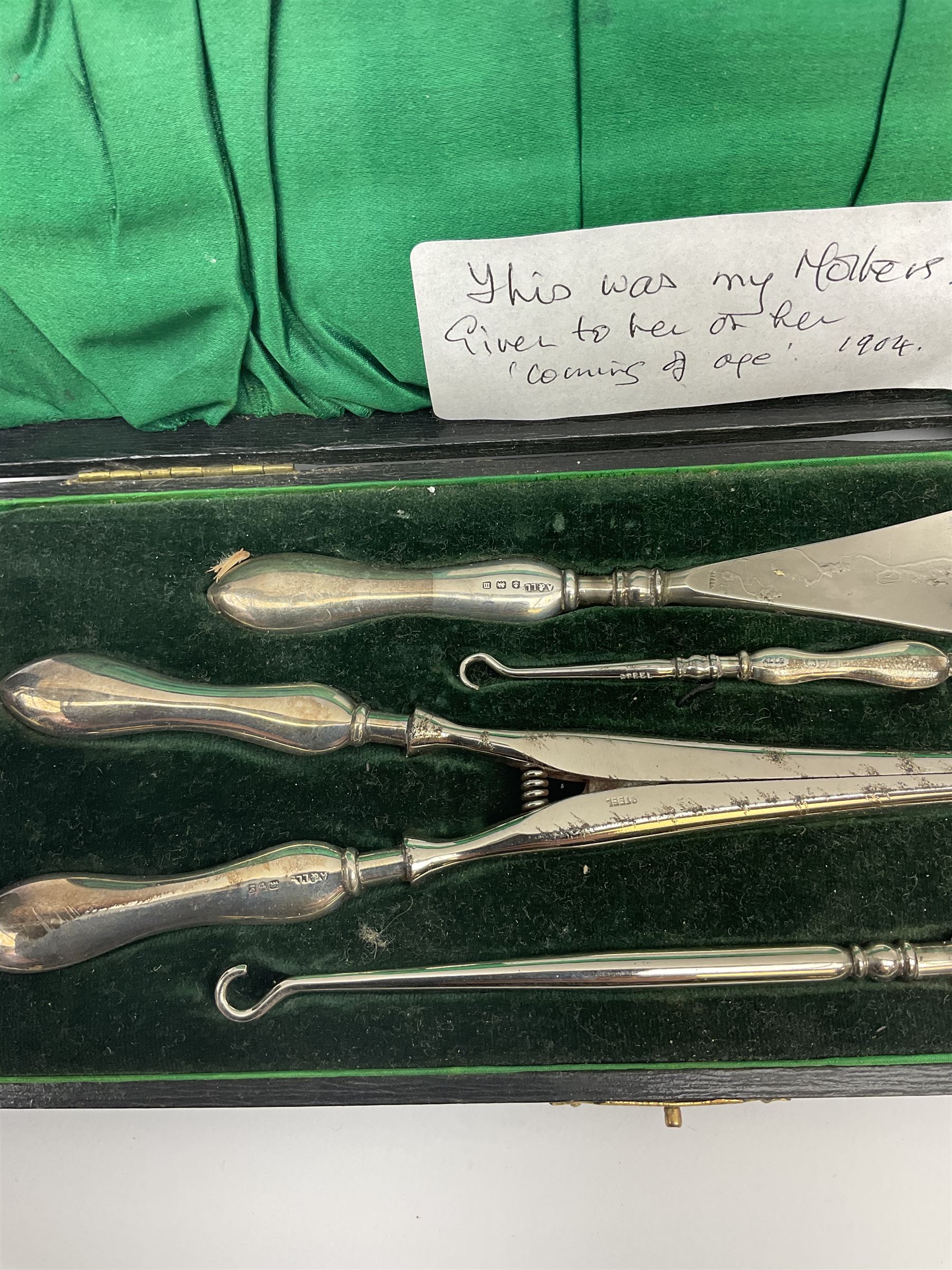 Cased silver handled glove stretcher, button hook, shoe horn, etc., hallmarked Adie & Lovekin Ltd, Chester 1911, and Adie & Lovekin Ltd, Birmingham 1911, miniature silver mounted hymn book, the cover embossed with cherubs, silver handled button hook, ivory handled button hook with silver ferrule, two silver dressing table pot lids, etc. 