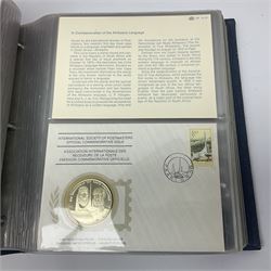 Thirty-one 'International Society of Postmasters Official Commemorative Issues' sterling silver proof medallic covers dating from 1975 to1977, housed in the official folder and a 'Commemorating The Bicentennial Of The United States Of America' sterling silver proof medallic first day cover in blue wallet