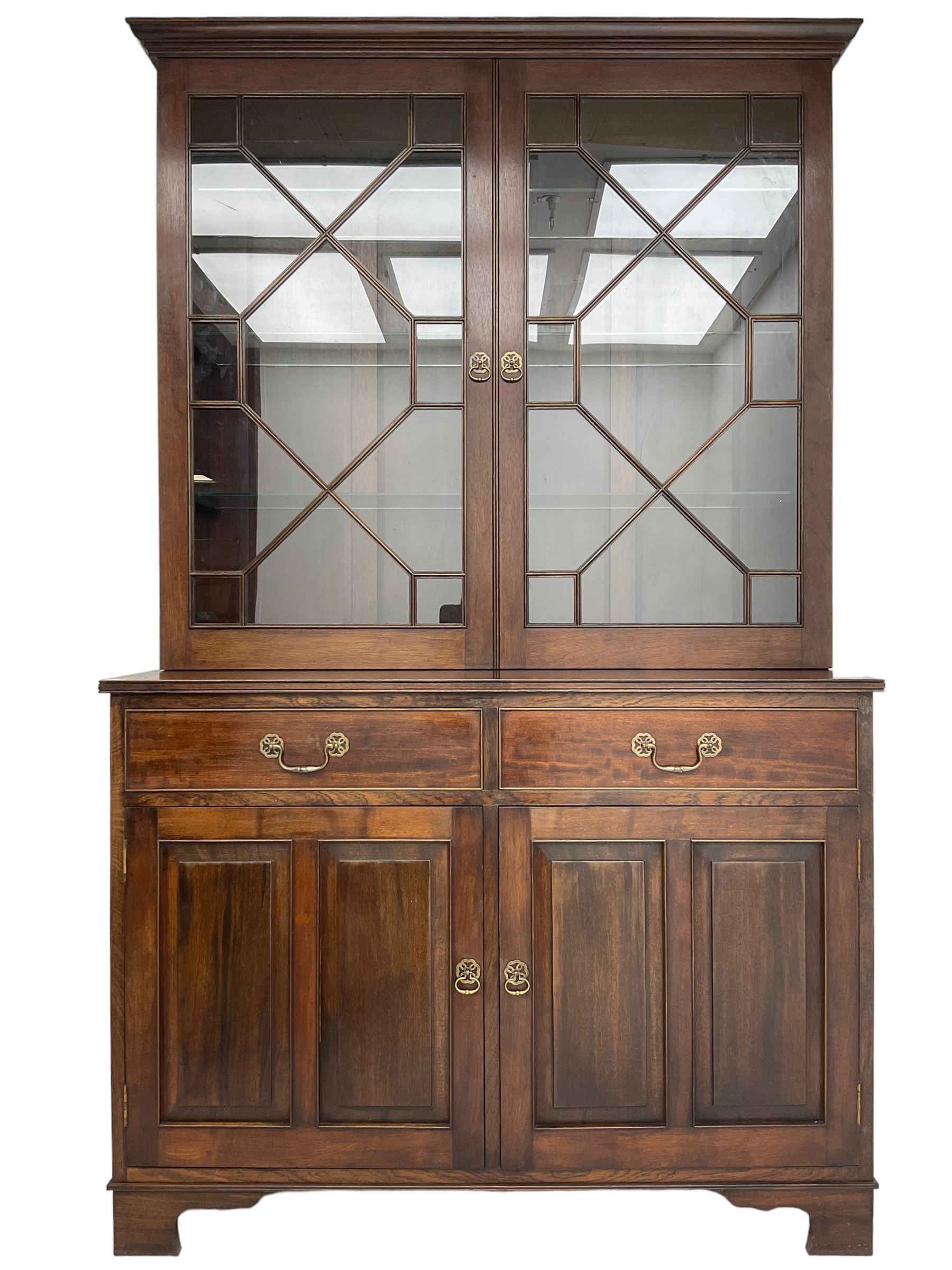Acorn Industries - Georgian design mahogany bookcase on cupboard, fitted with two astragal glazed doors enclosing three glass shelves, base with two cock-beaded drawers over two panelled cupboards, inlaid with acorn signature, by Alan Grainger, Brandsby