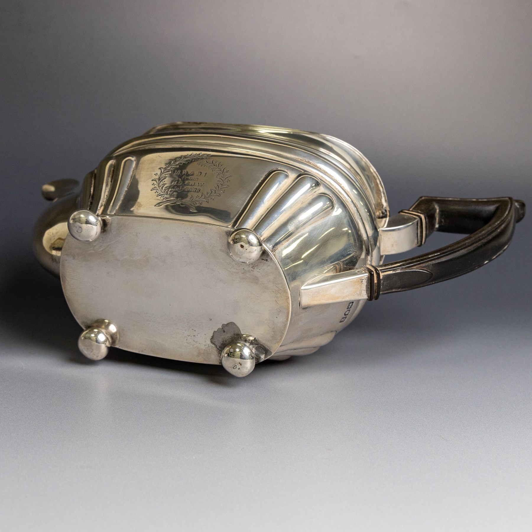 Edwardian silver teapot, of part fluted oval form upon four bun feet, with ebonised handle and finial and presentation engraving to body, hallmarked Thomas Bradbury & Sons, London 1904, H17cm