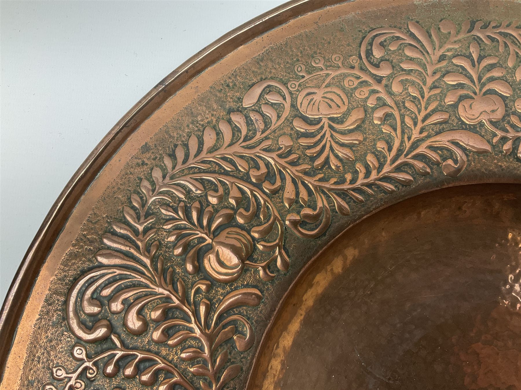 Arts and Crafts Keswick School of Industrial Arts copper charger, decorated with planished centre and repousse scrolling foliate tendrils to rim, D44cm