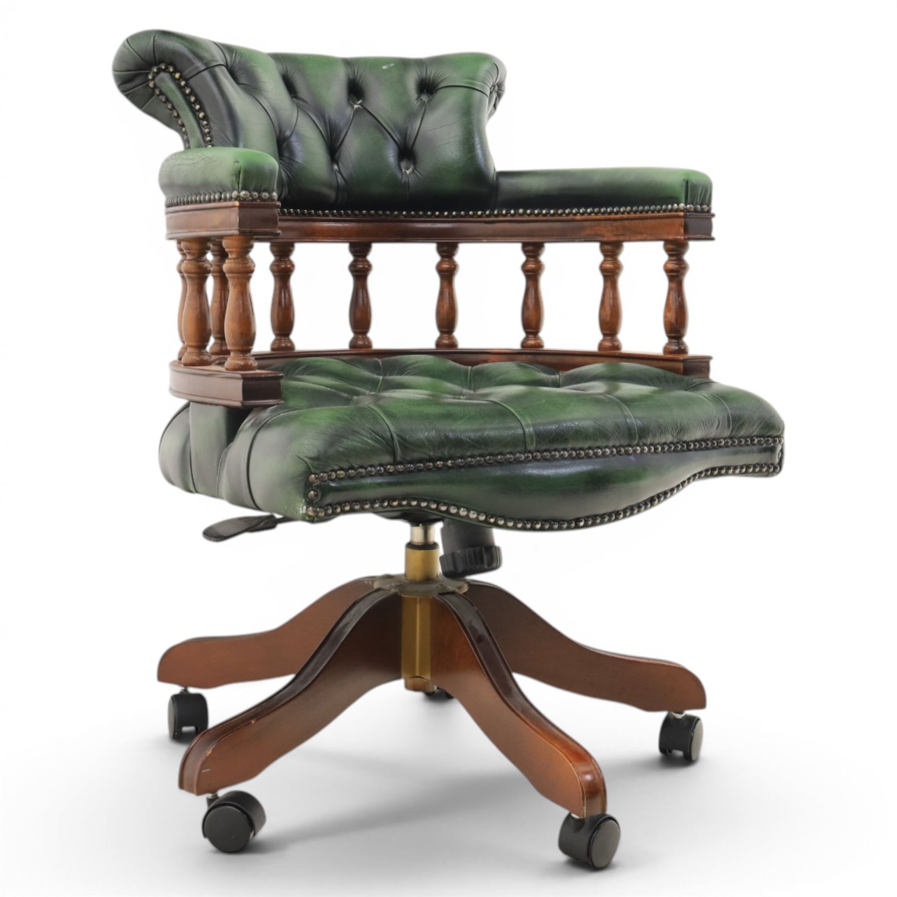 Captains swivel desk chair upholstered in buttoned green leather, five point star base raised on castors