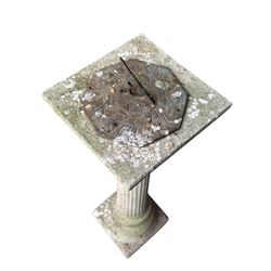 Weathered cast stone sundial on fluted pedestal