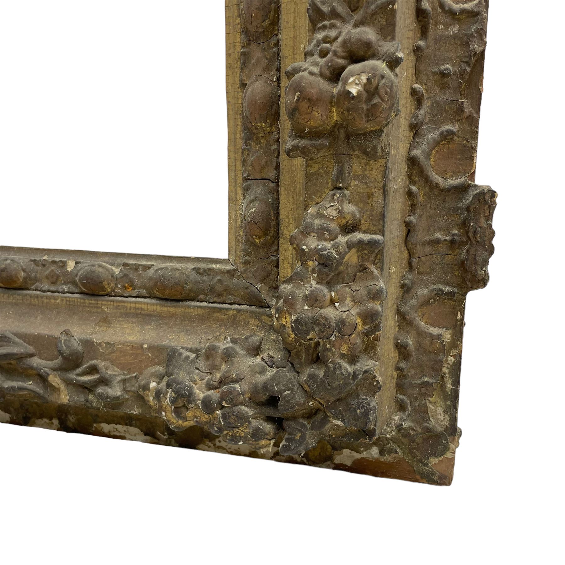 19th century giltwood and gesso moulded picture or mirror frame, the arched cresting rail mounted by central cartouche decorated with foliate scrolls and fruit, the outer frame decorated with scalloped edge and shell mouldings, trailing foliage with flower head and fruit to the central band, egg and dart moulded inner slip