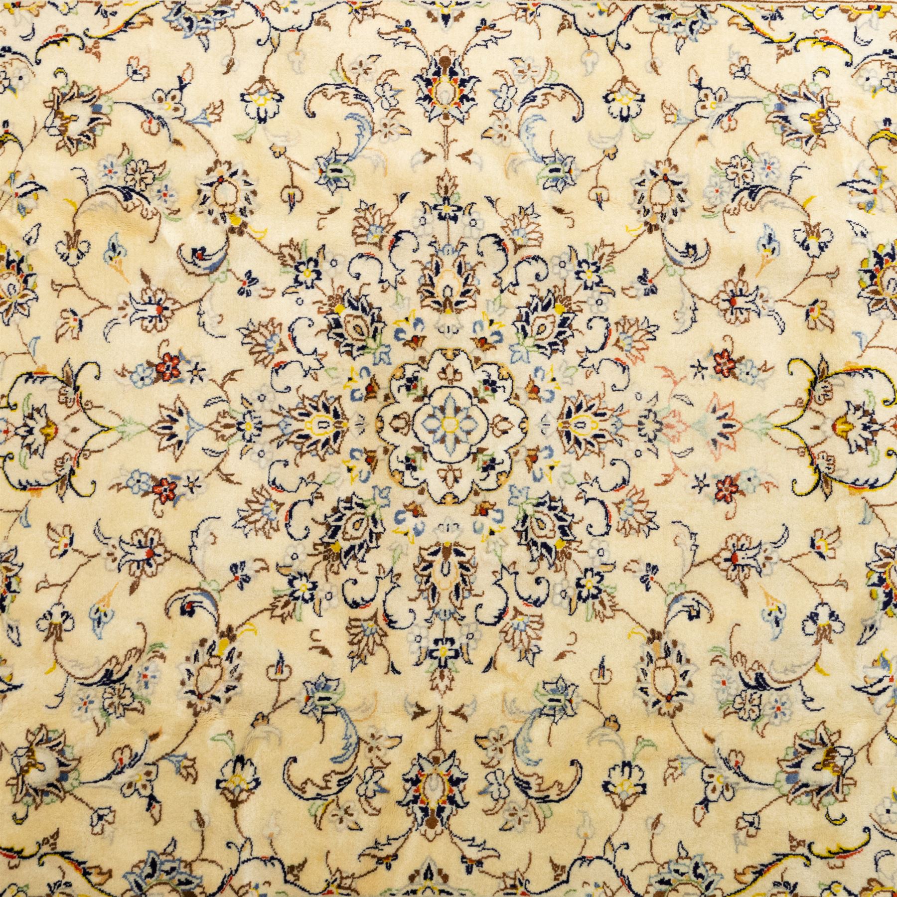 Central Persian Kashan hand-knotted carpet, ivory ground, with a central shaped floral medallion with pendants, surrounded by scrolling foliate and floral motifs incorporating rosettes, palmettes and delicate vine work, enclosed by a conforming ivory border with repeating palmettes and meandering vines, flanked by floral guard stripes, with cotton fringes