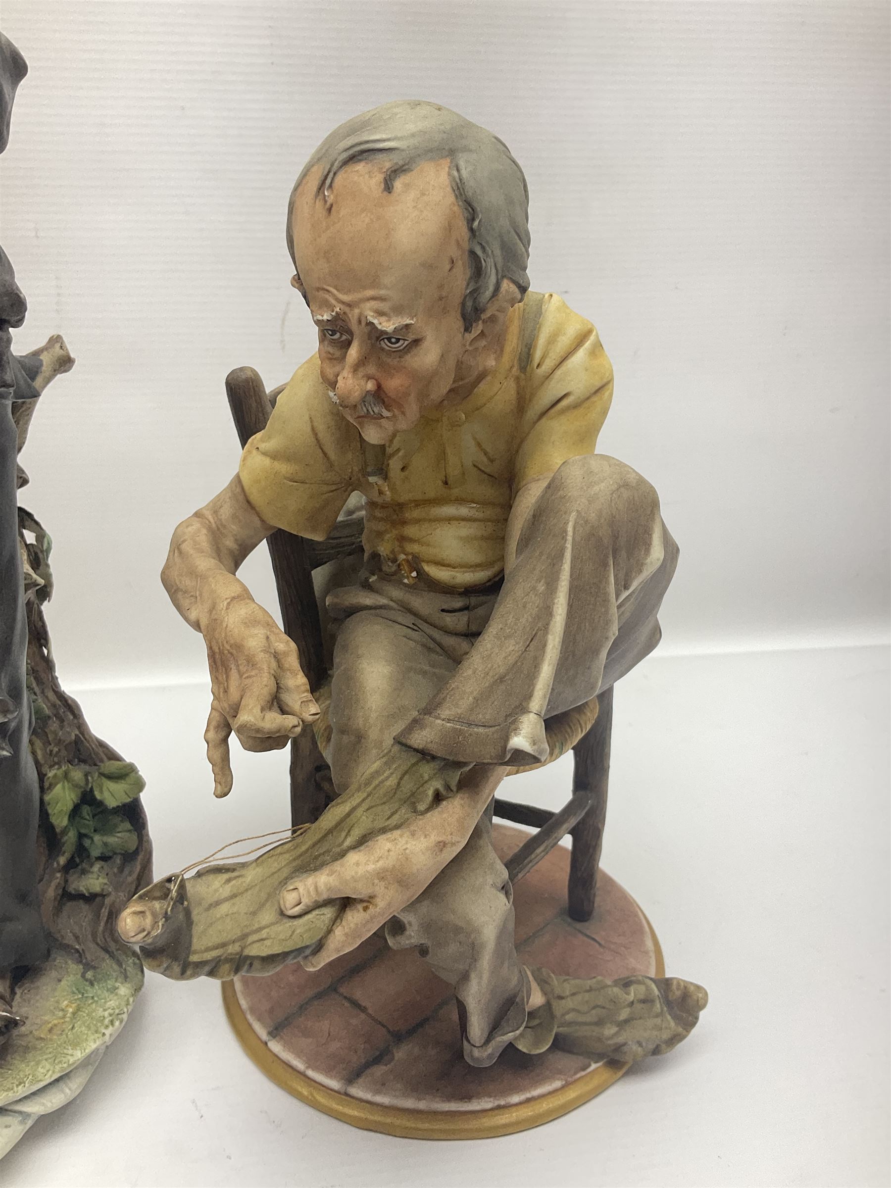 Three Capodimonte figures, to include The Kind Heart Man, modelled by Cortese as a tramp with two doves, The Young Falconer by Maria Angela and another modelled as a tramp darning his socks, all with printed marks, tallest H39cm