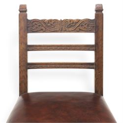 Craftsman made set of four solid oak dining chairs with leather seats, with carved cresting rail, on red leather seats with studded trim, raised on block and turn supports united by H-stretcher