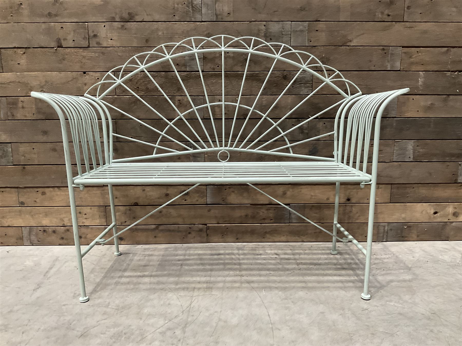 Wrought metal two seat garden bench, sunburst back, painted in pale green finish