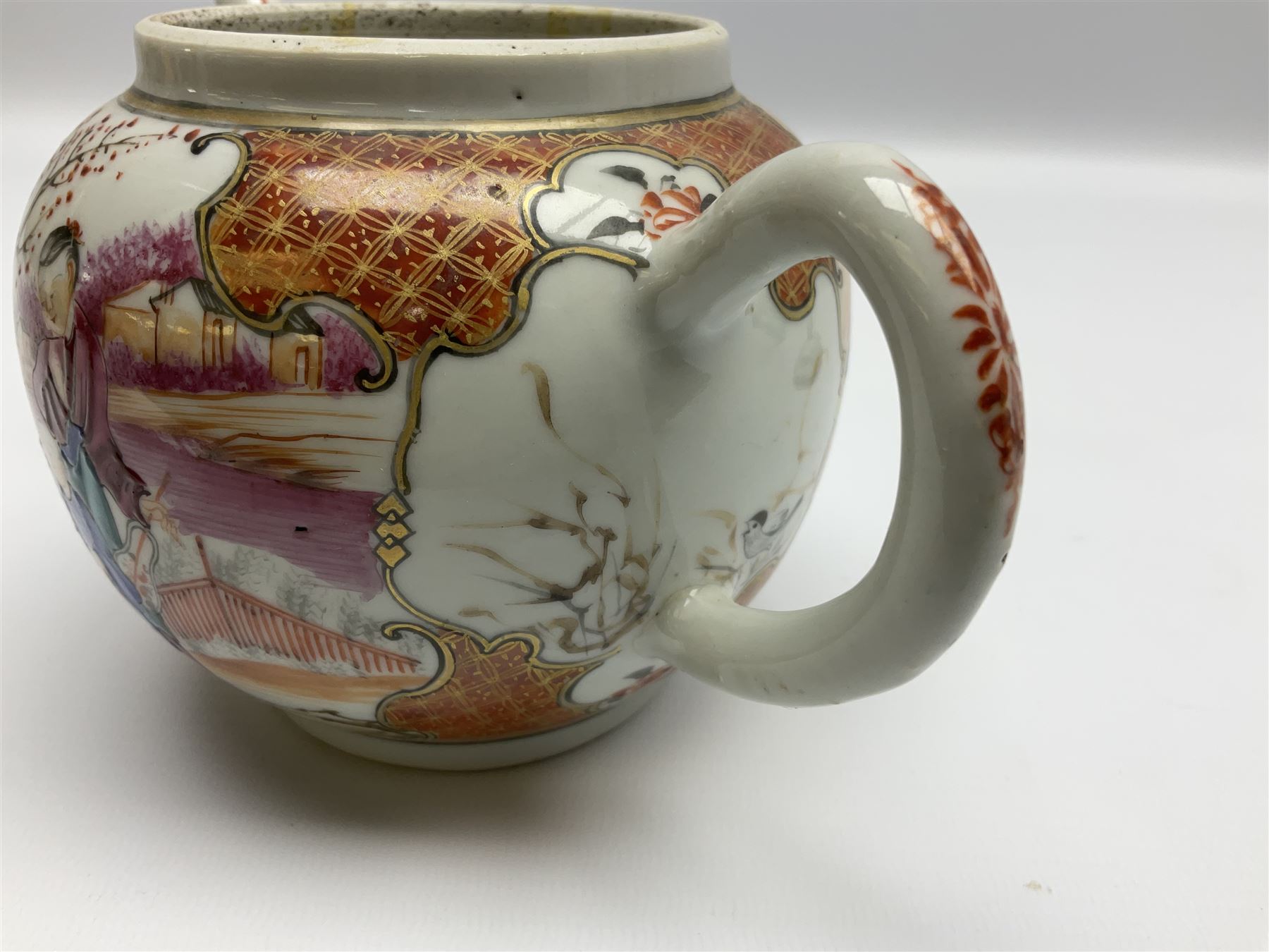 Two late 18th/early 19th century Chinese export teapots, the largest example of globular form with curved handle and straight spout, decorated in the Mandarin style with figural scenes surrounded by red scale reserves, H13.5cm, the second smaller example decorated in underglaze blue with two musicians in a landscape set with willow tree and fence, H10.5cm

