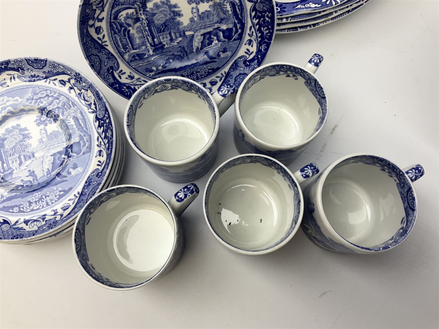 Spode blue and white Italian pattern dinner and tea wares, comprising five dinner plates, four side plates, seventeen side plates, four bowls, ten tea cups and twenty one saucers, five coffee cans and six saucers, and a flan dish, with blue and black printed marks beneath 
