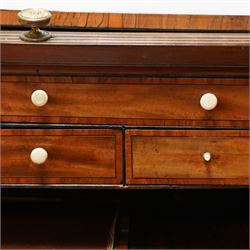 George III mahogany cylinder front writing desk, the hinged tambour enclosing pigeonholes and drawers with bone handles, sliding writing surface with leather inset, three frieze drawers below, on square tapering legs with brass caps and castors