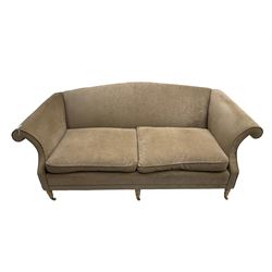 Traditional three seat sofa, curved back over scrolled arms, upholstered in crushed beige fabric with matching loose cushions, on turned front supports with brass and ceramic castors, together with matching footstool