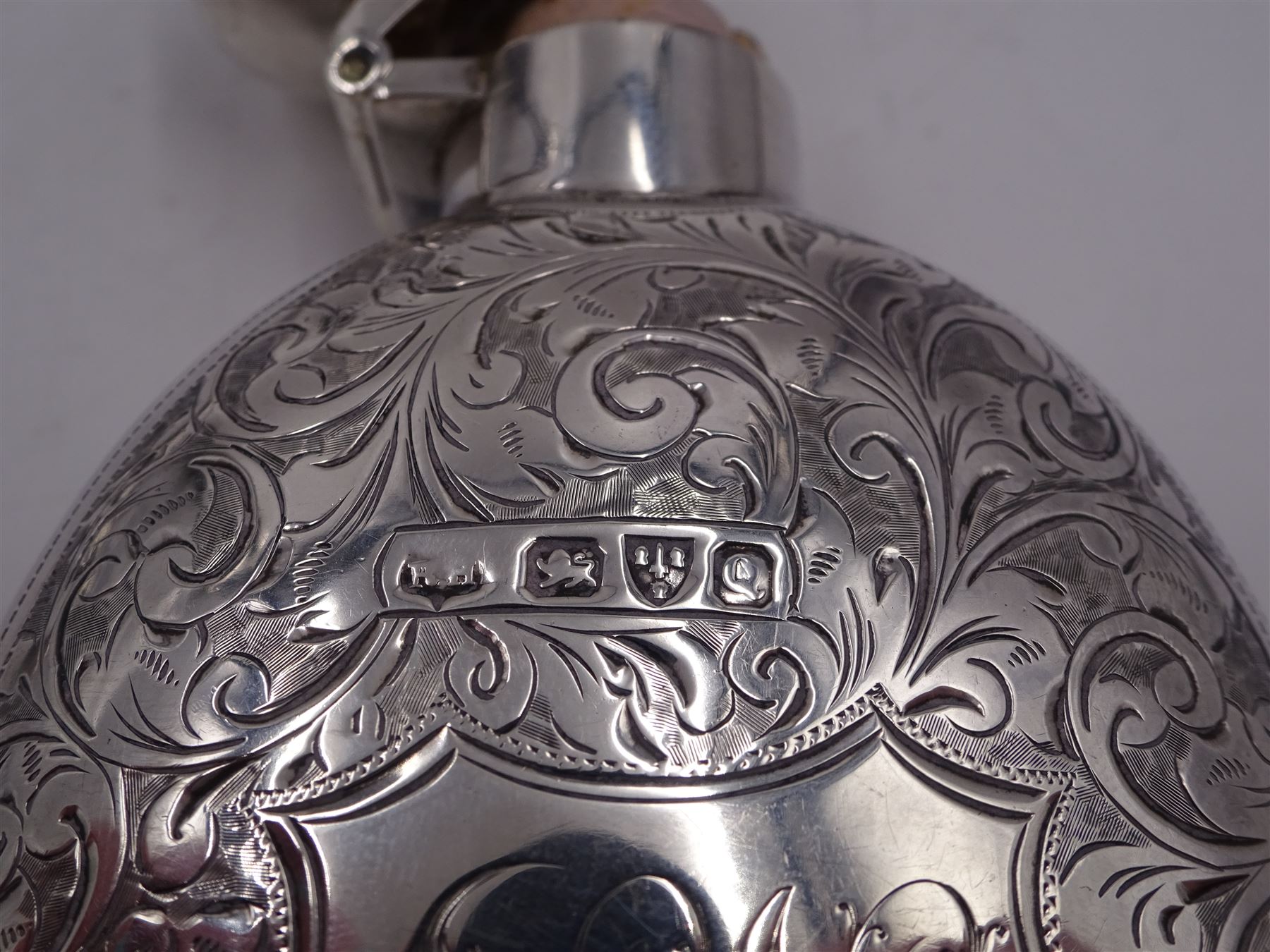 Victorian silver hip flask, of oval form, with engraved foliate and scroll decoration, and monogrammed shield shaped cartouche to centre, with plain collar and cap, H11cm, hallmarked Chester 1899, maker's mark worn and indistinct, together with an Edwardian silver glasses case, of oval form, with engraved foliate and scroll decoration, and monogrammed circular shaped cartouche to centre, with opening to top, revealing velvet lined interior, with silver shield clip, H17.5cm hallmarked to case and clip Sanders & Hill,  Birmingham 1908, with a pair of gold plated glasses 