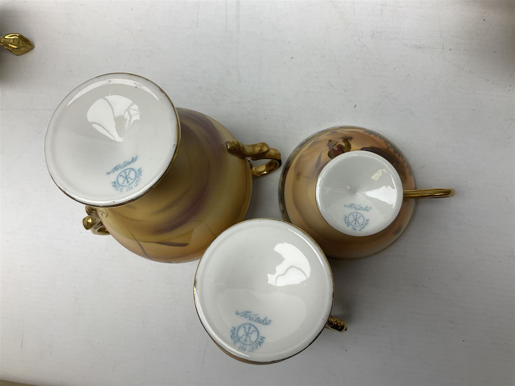 Noritake tea service for four, decorated with desert camel scene with blue border and gilding, comprising four teacups and saucers, four side plates, lidded sucrier, teapot and jug, together with twin handled pedestal bowl etc (19 pcs) 