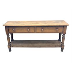Late 19th century oak potboard dresser base, rectangular top over two frieze drawers with turned wooden handles, raised on four ring turned and tapering supports with block feet, united by a full-width lower potboard