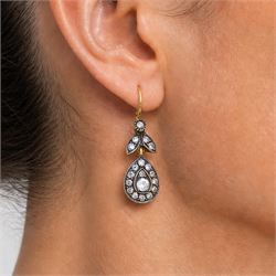 Pair of gold and silver diamond earrings, each pendant with pear shaped drop set with round brilliant cut and single cut diamonds, suspended from a diamond set leaf design bail, total diamond weight approx 1.00 carat