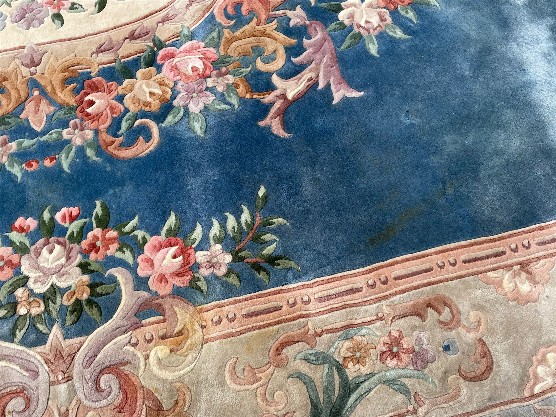 Large Chinese blue ground woollen carpet, overall floral design, central oval medallion surrounded by scrolling floral decoration, wide border with decorated with floral bouquets 