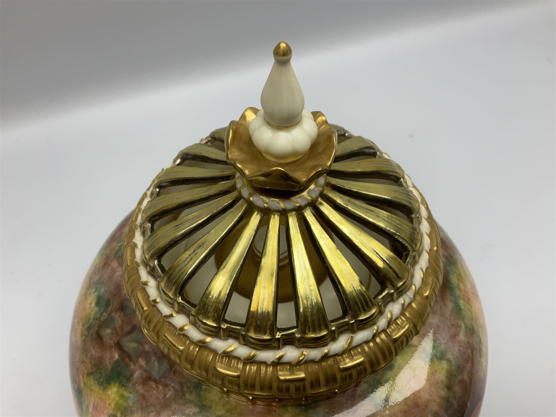 Mid 20th century Royal Worcester potpourri vase and cover decorated by Alan Telford, of ovoid form with inner cover and pierced gilt outer cover with bud finial, upon short gilt circular foot, the body part moulded with basket weave bands in gilt and bronze, and hand painted with a still life of fruit upon a mossy ground, signed Telford, with black printed mark beneath and painted shape number 1286, H25.5cm