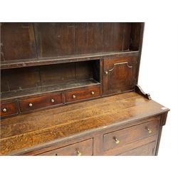 18th century oak dresser, the raised plate rack fitted with two cupboards and three small drawers, the base fitted with six drawers and two cupboards, enclosed by two fluted pilasters, on bracket feet 