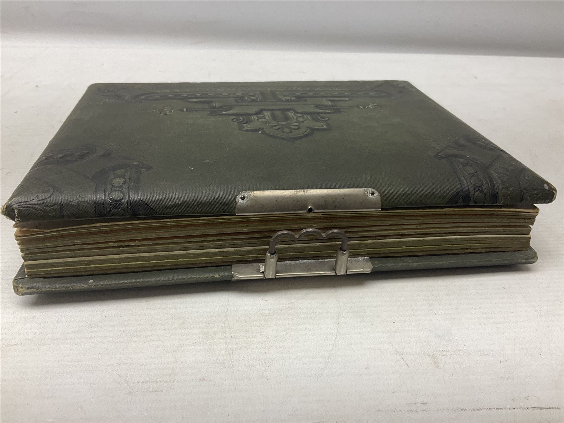 Victorian desk ink blotter, decorated with painted spray of flowers within stylised gilt rococo spandrels with mother of pearl fixings, together with a Victorian photo album containing interior leaves with apertures of various sizes and shapes of portraits surrounded by printed sea and dock scenes, blotter L28cm
