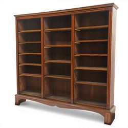 Quality Edwardian inlaid mahogany triple-column open bookcase, projecting cornice over a satinwood banded frieze, fitted with fourteen adjustable shelves with strung facias, the shaped apron on bracket feet