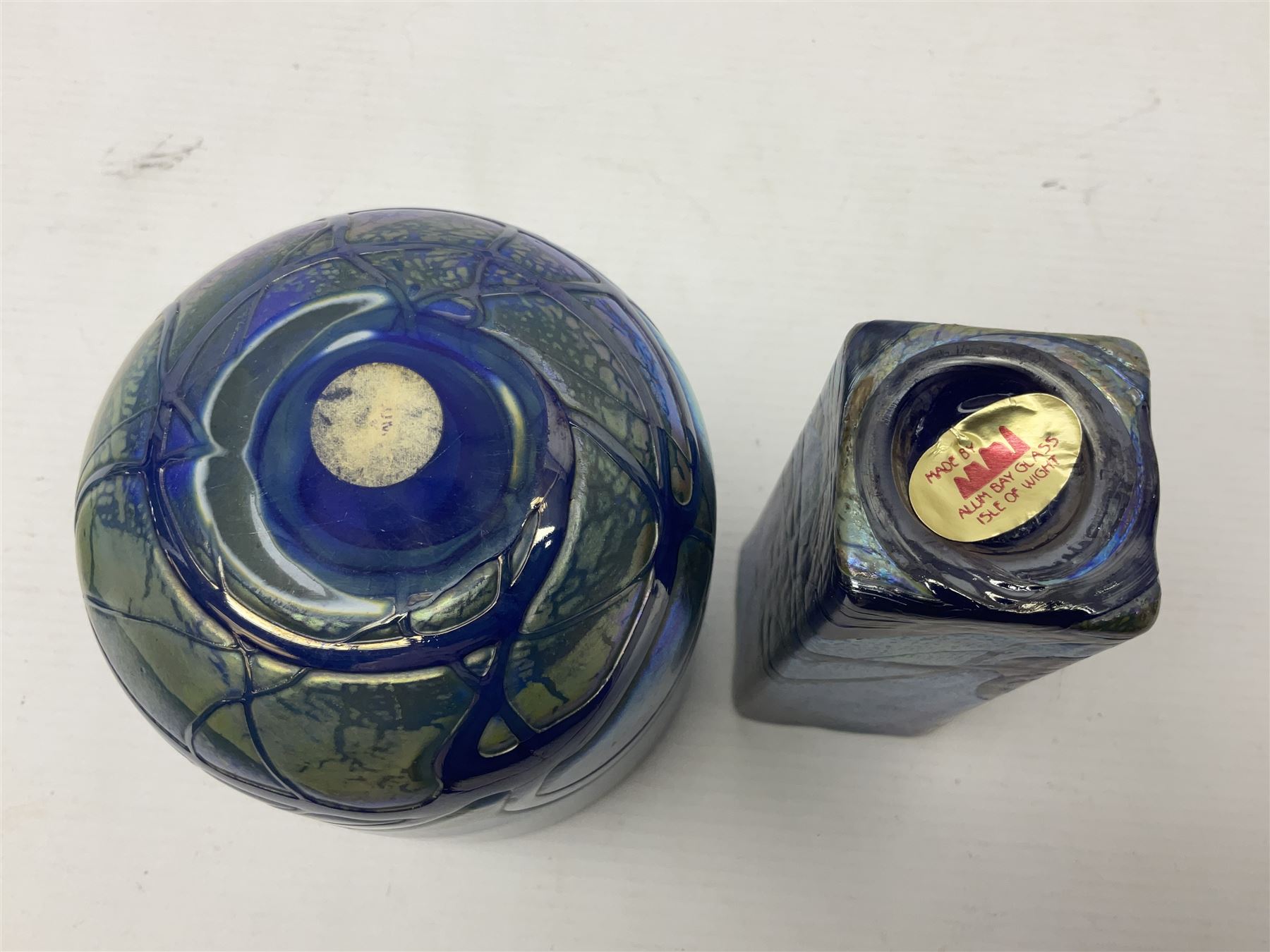 Two Isle of White glass vases, by Alum Bay Glass, both with blue swirl design upon an iridescent mottled blue/green ground, together with a Gozo Glass vase of pebble form, with similar design, H12cm