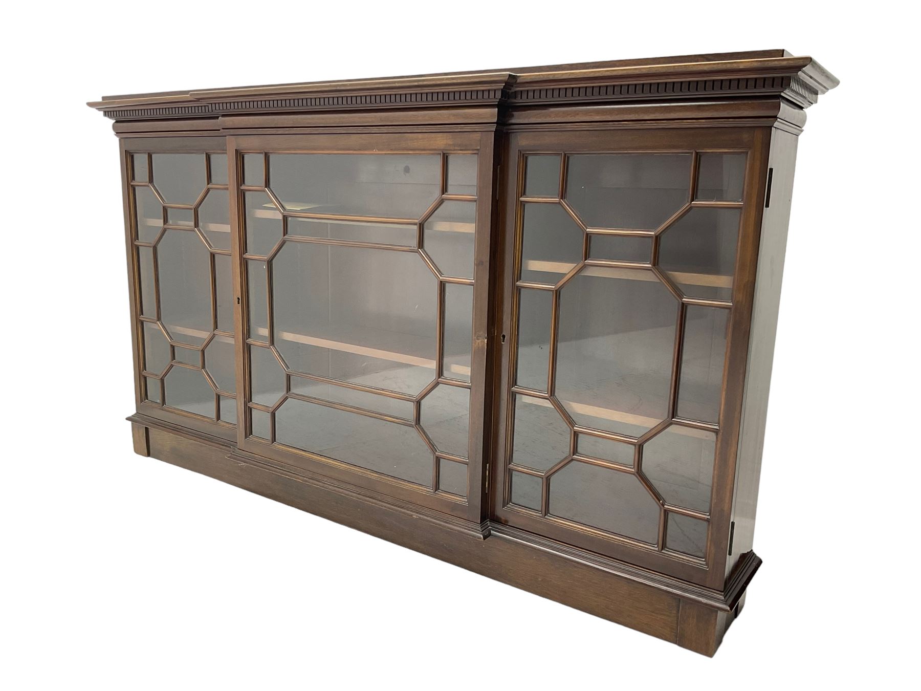 Early 20th century mahogany breakfront wall hanging bookcase, projecting dentil cornice over astragal glazed doors