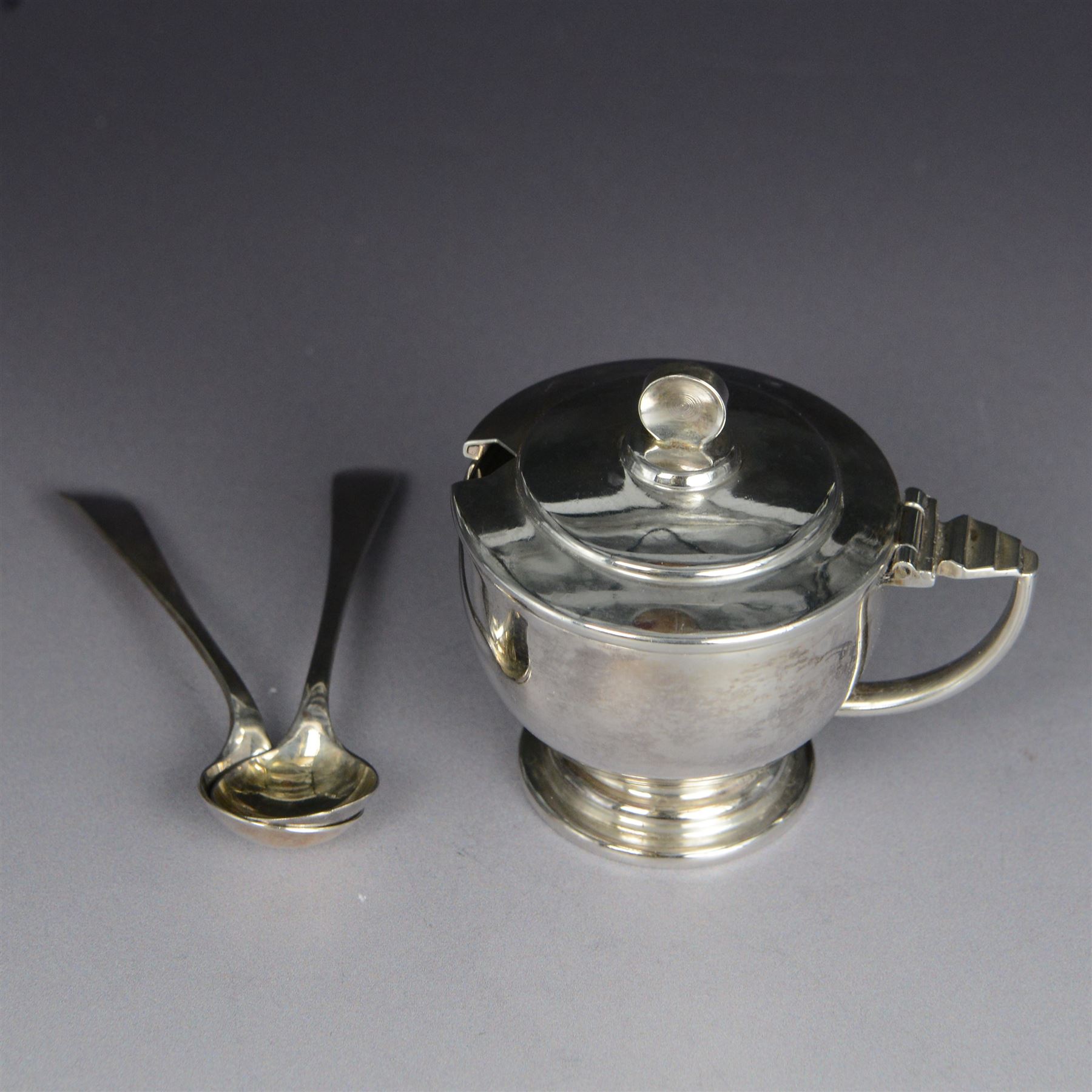 Art Deco silver five piece cruet set, comprising mustard pot, two pepper shakers and two open salts, hallmarked Hukin & Heath Ltd, Birmingham 1937, together with two silver salt spoons, hallmarked, mustard pot and salts with frosted glass liners, all contained within fitted tooled leather case